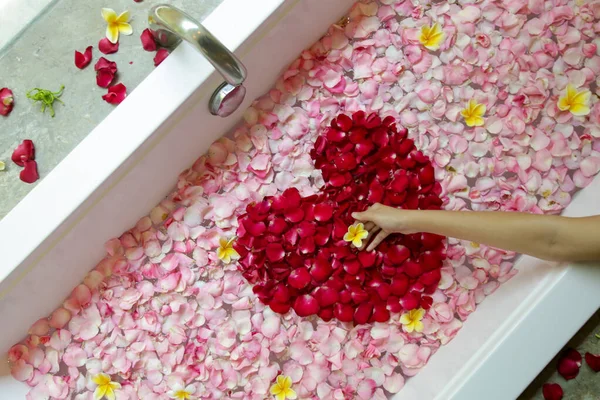 バラとフランジパニの花びらでいっぱいの浴槽 スパの週末 ボディケアと美しさの概念 — ストック写真