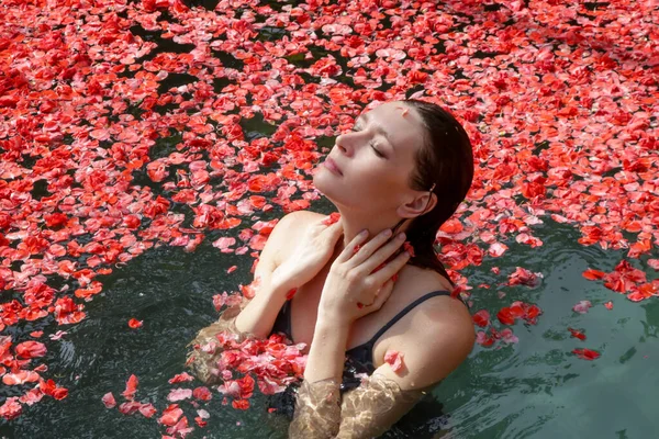 Женщина Отдыхает Красных Лепестках Розовых Цветов Покрытый Бассейн Романтические Выходные — стоковое фото