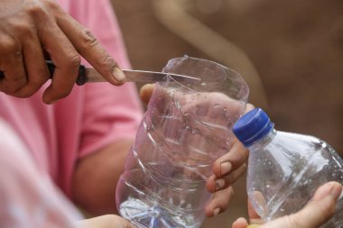 Atık plastikten bitkiler için kendi kendini sulama işlemi. Tek kullanımlık plastik şişe geri dönüşüm fikri. Sıfır atık sürdürülebilir yaşam tarzı kavramı.