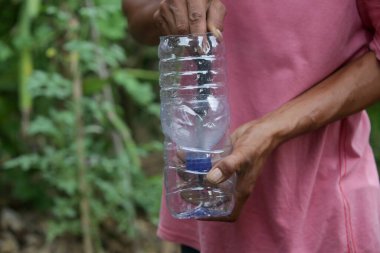 Atık plastikten bitkiler için kendi kendini sulama işlemi. Tek kullanımlık plastik şişe geri dönüşüm fikri. Sıfır atık sürdürülebilir yaşam tarzı kavramı.