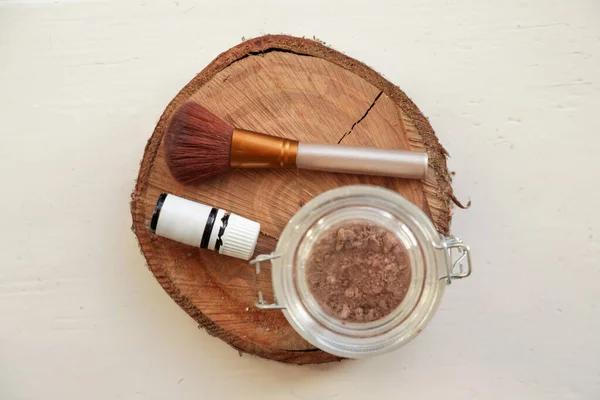 A jar of organic non-toxic chemicals free dry shampoo. DIY project for healthy low toxic living. Simple shampoo powder containing just natural ingredients, cocoa powder, cornstarch and essential oil.