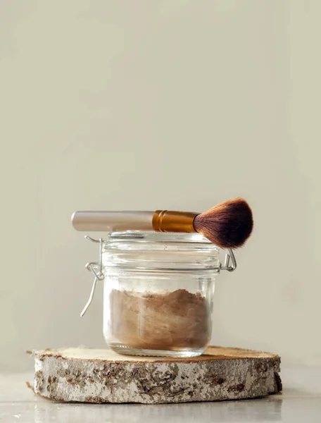 A jar of organic non-toxic chemicals free dry shampoo. DIY project for healthy low toxic living. Simple shampoo powder containing just natural ingredients, cocoa powder, cornstarch and essential oil.