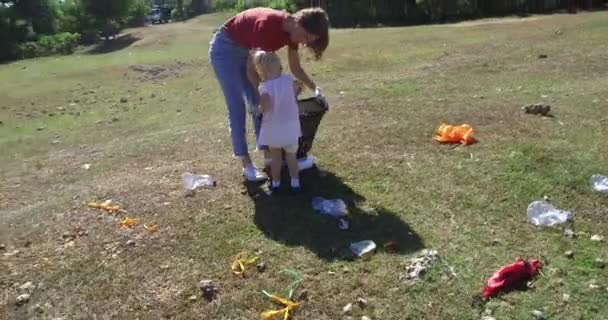 Mujer Joven Recogiendo Residuos Plástico Pradera Con Hija Pequeña Recoger — Vídeos de Stock