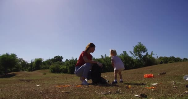 Mujer Joven Recogiendo Residuos Plástico Pradera Con Hija Pequeña Recoger Metraje De Stock Sin Royalties Gratis