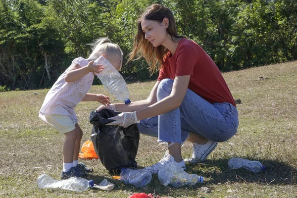 Mujer Joven Recogiendo Residuos Plástico Pradera Con Hija Pequeña Recoger — Foto de Stock