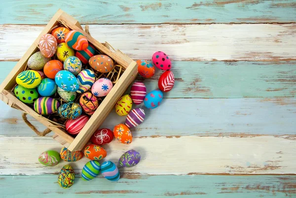 Easter background with Easter eggs. Easter eggs on wooden background.  Top view with copy space.