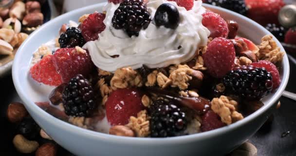 Frukost på spannmål med bär, torkad frukt, mjölk och vispgrädde — Stockvideo