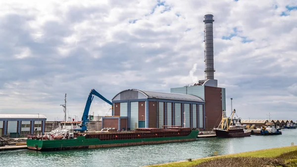 Frachtboot neben einem Kraftwerk Stockfoto