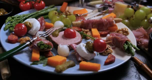 Een schotel van gerookte vlees (charcuterie), ham, salami, tapenade en kaas — Stockvideo