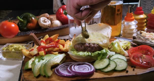 Añadir cornichones sobre una hamburguesa con queso — Vídeo de stock