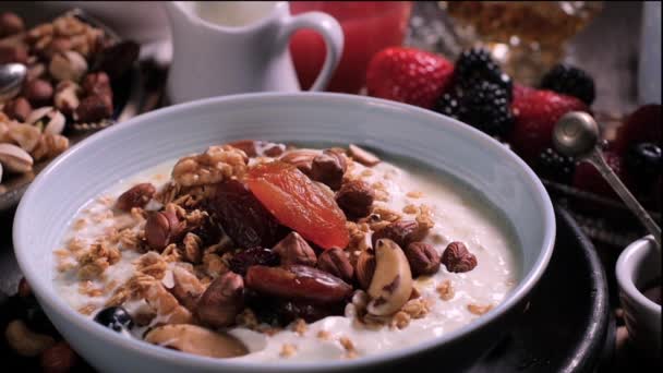 Zeitlupe: Beeren fallen über eine Schüssel Joghurt zum Frühstück — Stockvideo