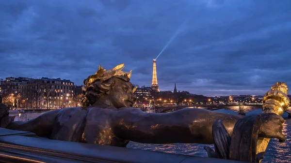 Uma estátua na ponte Alexandre III em Paris e a torre Eiffel ao pôr do sol — Fotografia de Stock