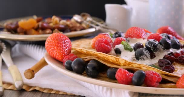 Dolly Blick auf ein Frühstück mit Pfannkuchen mit Beeren und Trockenfrüchten — Stockvideo