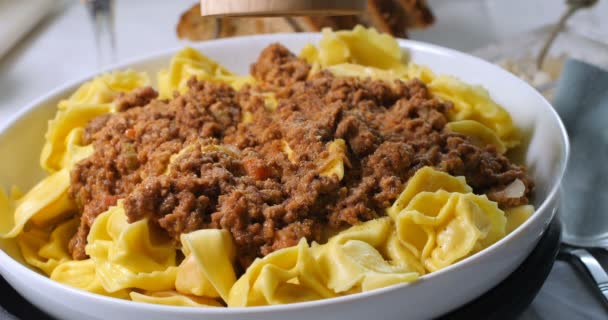Beregening van zwarte peper over heerlijke stomende tortellini in bolognese saus — Stockvideo