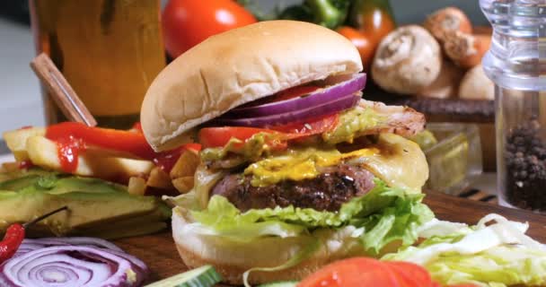 Dolly push out view of a cheeseburger with French fries and beer — Stock Video