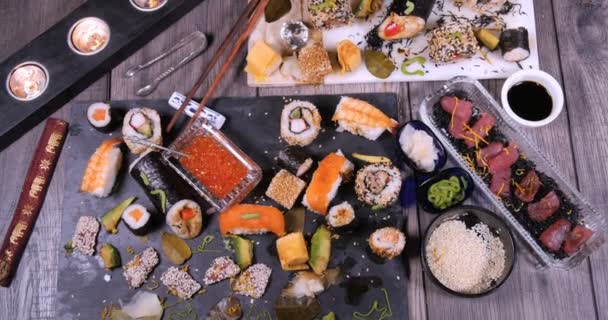 Top down zoom in view of an assortment of Japanese food: sushi, nigiri, sashimi — Stock Video