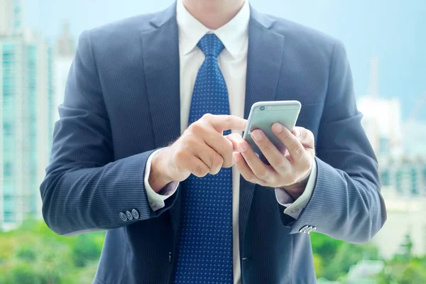 İş adam ellerini kullanan akıllı telefon üzerinden şehir görünümü backgro bulanıklık