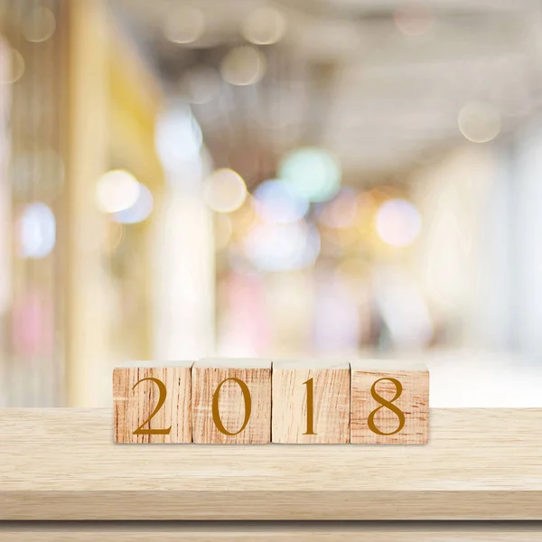 Holzwürfel mit 2018 auf dem Tisch über verschwommenem Bokeh-Hintergrund mit — Stockfoto