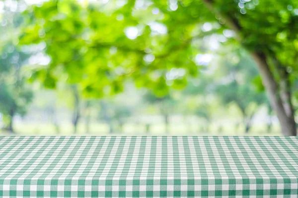 Masa goala cu fata de masa verde peste gradina neclara si bokeh bac — Fotografie, imagine de stoc