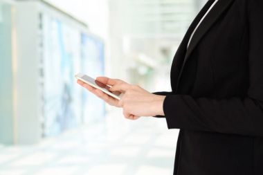 İş kadını eller üzerinde akıllı telefon kullanma office backgrou bulanıklık
