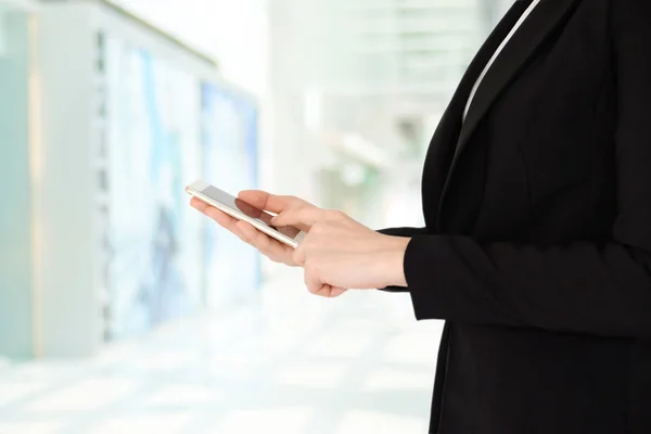 Mujer de negocios manos utilizando el teléfono inteligente sobre borroso backgrou oficina — Foto de Stock