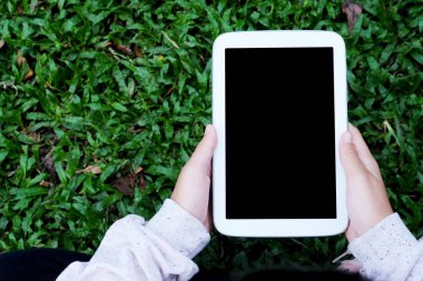 Boş ekran tablet yeşil otlar arka plan üzerinde kullanma el mo