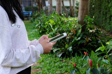 Kadın el tablet yeşil park arka plan üzerinde kullanma