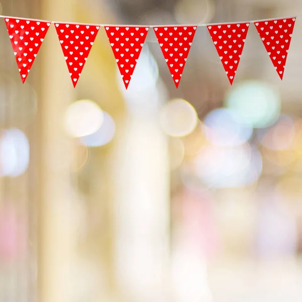 Red bunting party flag with heart pattern on blur bokeh backgrou