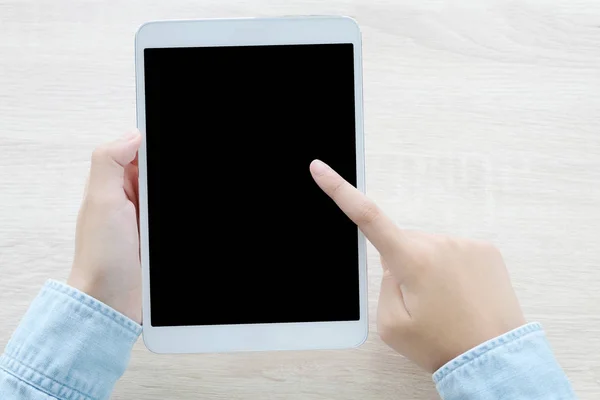 Mano usando la tableta con la pantalla en blanco para la maqueta encima del respaldo de la tabla — Foto de Stock