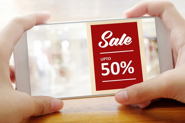 El satış promosyon ile akıllı telefon ekranda görüntü üzerinde tutarak.
