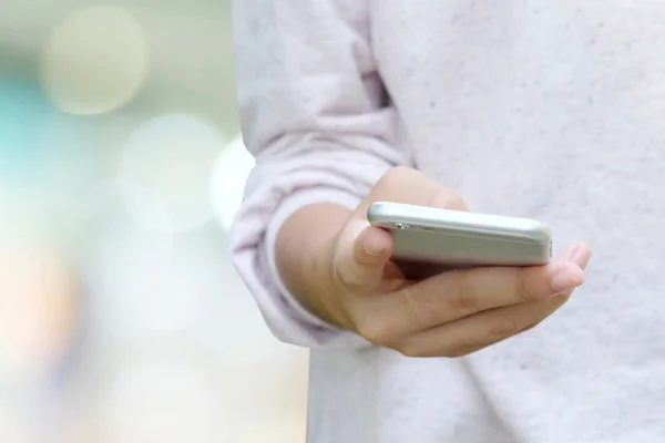 Kadın el kullanan akıllı telefon üzerinden bokeh arka plan bulanıklık