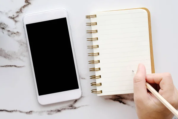 Smartphone mit leerem Bildschirm und Bleistift in der Hand — Stockfoto