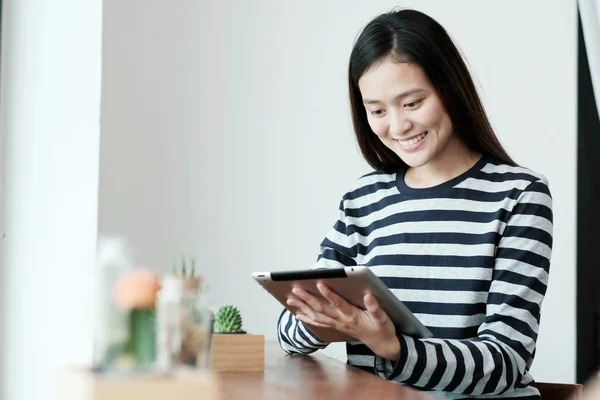 Asya kadın kafe arka planda otururken tablet kullanma, 