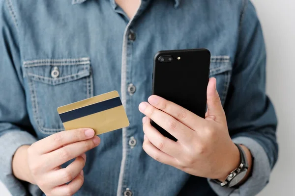 Man hands using smart phone and holding credit card, shopping on