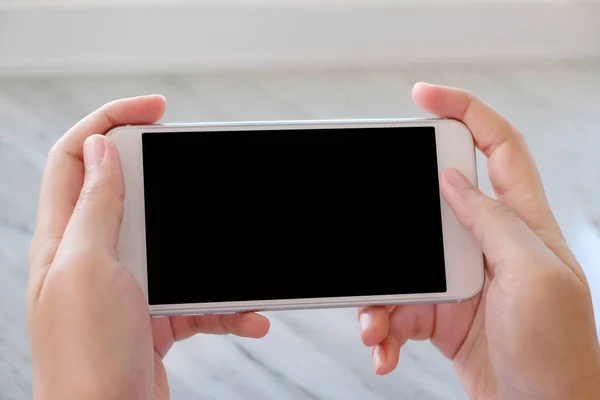 Hombre de mano sosteniendo teléfono inteligente blanco con pantalla en blanco en backgrou — Foto de Stock