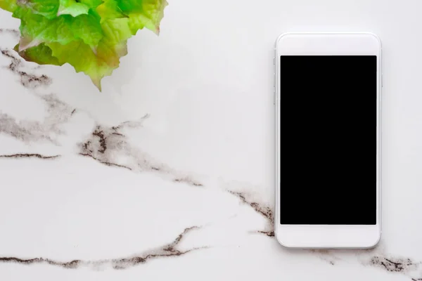 Teléfono inteligente blanco con pantalla en blanco en la mesa de mármol blanco backgr — Foto de Stock