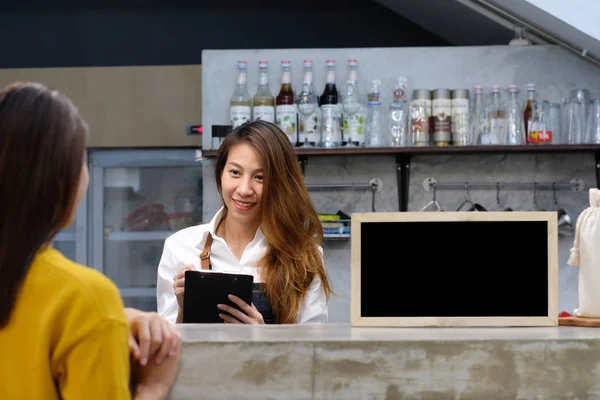 Молодой азиатский бариста принимает к сведению, заказ, в кафе счетчик W — стоковое фото