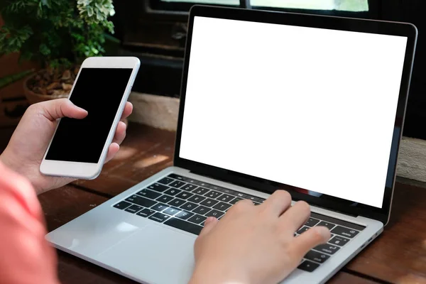 Hombre manos escribiendo ordenador portátil y teléfono inteligente con scre en blanco — Foto de Stock