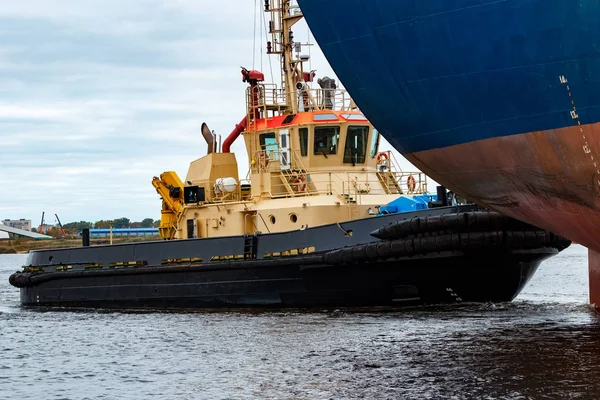 Tug ship towing blue bulk carrier — Stock Photo, Image