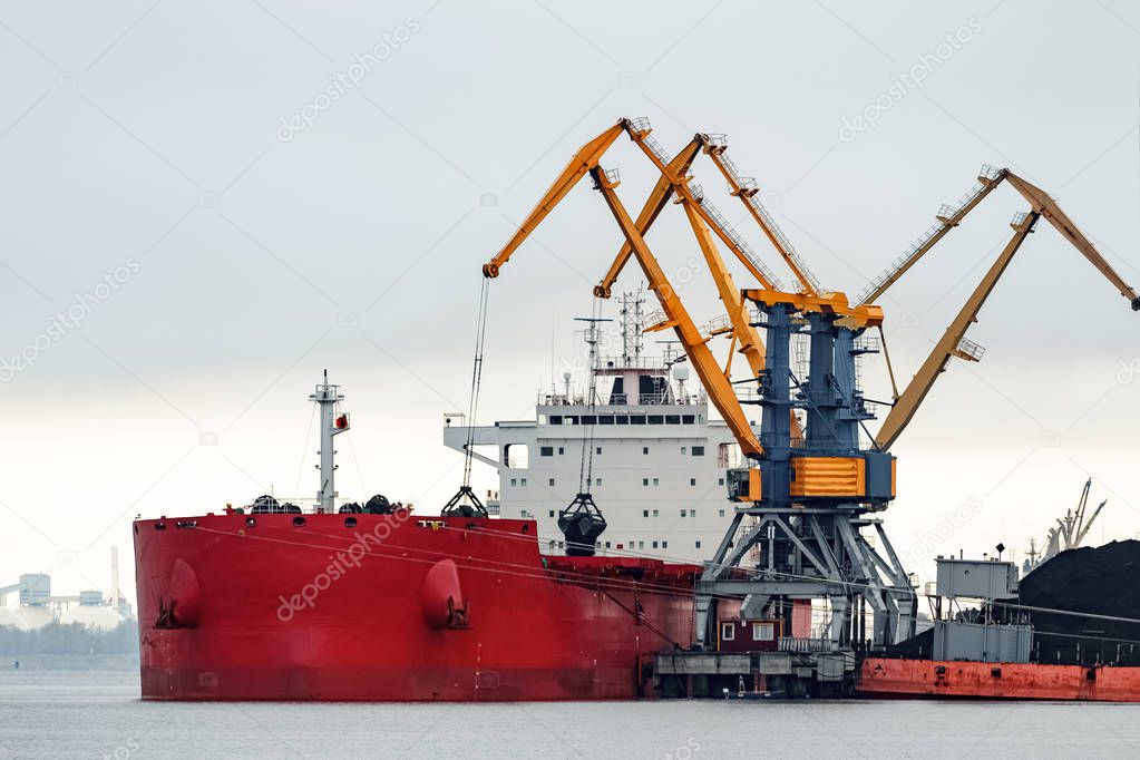 Large red cargo ship loading