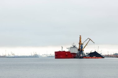 Büyük kırmızı kargo gemisi yükleniyor
