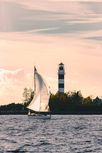 Sailboat moving past the big lighthouse