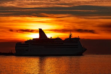 Turuncu günbatımı gökyüzü karşı hareketli beyaz yolcu gemisi