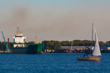 Yeşil kargo gemisi liman açık bir günde bırakır.
