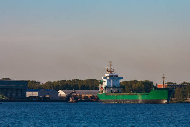 Yeşil kargo gemisi liman açık bir günde bırakır.