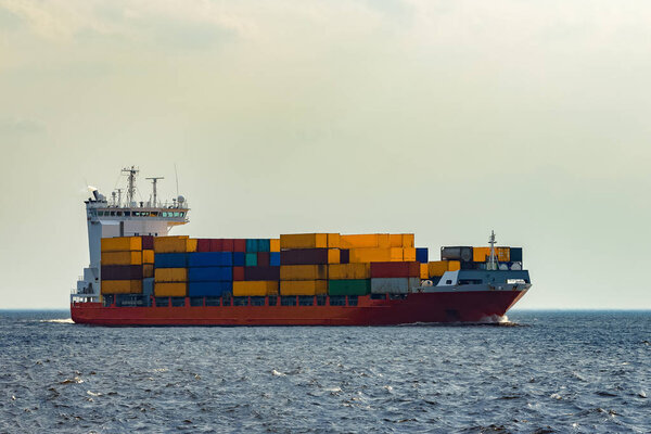 Red container ship underway