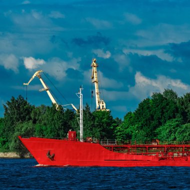 Nehir kenarında hareketli kırmızı kargo tanker gemisi