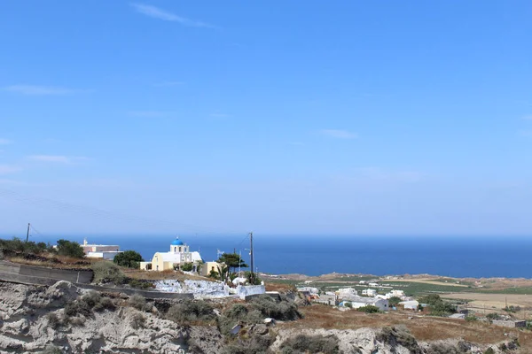 Iglesia junto a la montaña en una pequeña ciudad en Santorini — Foto de Stock