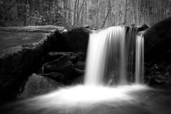 Langsame Verschlusszeit Naturaufnahmen eines Wasserfalls mit moosbewachsenen Steinen. — Stockfoto