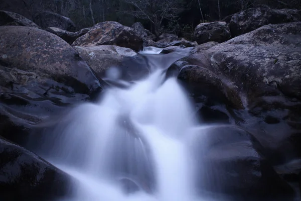 Langsame Verschlusszeit-Fotografie eines rauschenden Wasserfalls aus Flussfelsen — Stockfoto